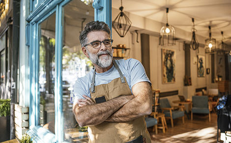 Small business owner leaning against the door frame.