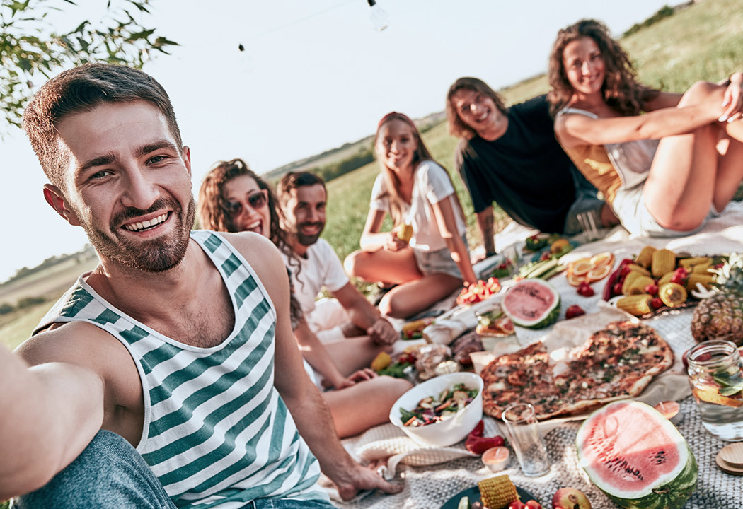 Young adults having a picnic in field.
