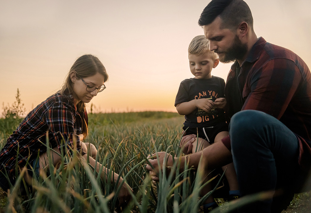 Farming family looking at their crops.
